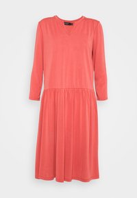 Korallfärgad knälång klänning i mjukt tyg, med V-ringning, långa ärmar och en rynkad midja med en utsvängd kjol.