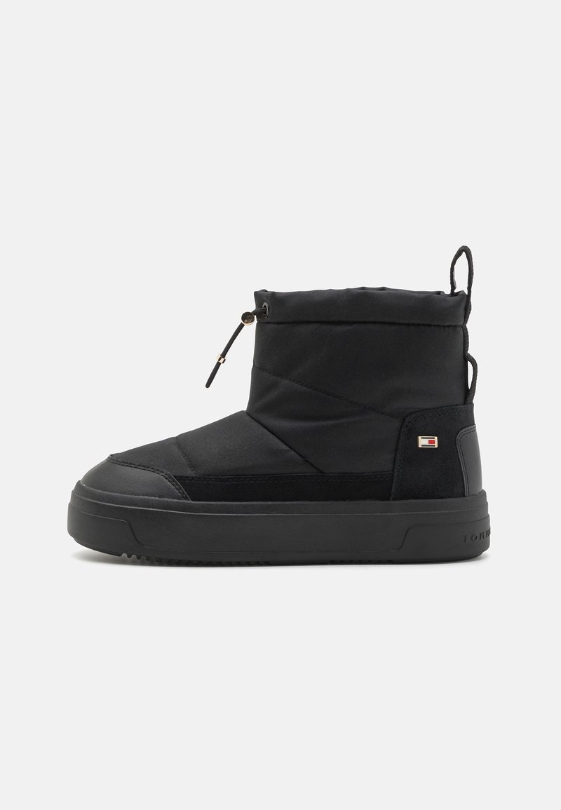 Svart ankelstøvler med quiltet stoff, gummisåle og snøring. Har en liten logo-patch på siden og myk tekstur.