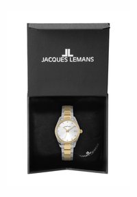 Jacques Lemans klocka i en svart låda. Har ett metallarmband i silver och guld, rund urtavla, vit urtavla, kristallaccenter och datumsdisplay.