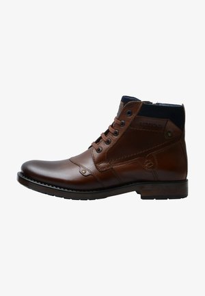 Bruine leren enkelboot met een ronde neus, vetersluiting en een marineblauwe textielen kraag. Voorzien van metalen oogjes en stiksels.