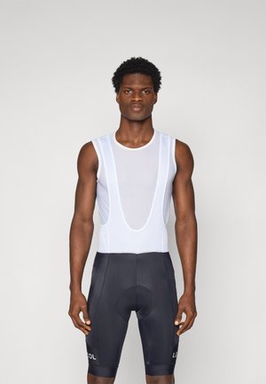 Tenue de vélo comprenant un haut sans manches en maille blanche avec un col rond et un short noir avec un rembourrage au niveau de l'assise et des accents de logo.
