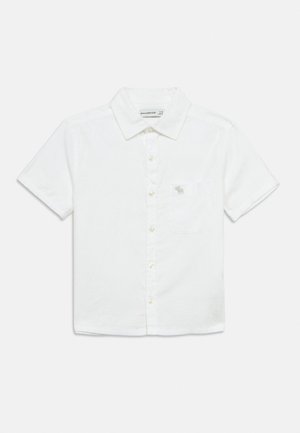 Camicia bianca a maniche corte con bottoni, colletto e taschino sul petto con un piccolo logo ricamato.