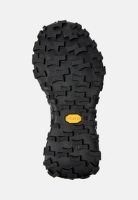 Suola Vibram nera con battistrada profondo e robusto per una migliore trazione. Logo prominente al centro. Superficie testurizzata che migliora la presa e la durabilità.