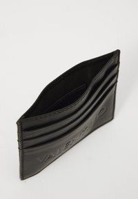 Porte-cartes en cuir noir avec logo embossé, comportant plusieurs emplacements pour cartes et une texture lisse. Design minimaliste avec des lignes épurées.