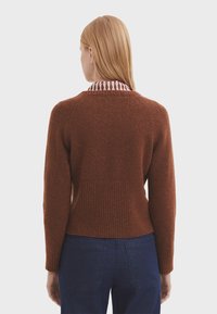 Rostfarbener Pullover aus strukturiertem Strickmaterial, mit einem gerippten Saum und Bündchen. Der Kragen hat ein kontrastierendes gestreiftes Design.