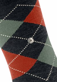 Klasyczne skarpetki argyle z ciemnym tłem oraz wzorem w czerwone, zielone i szare diamenty, zdobione białymi szwami i srebrnym logo.