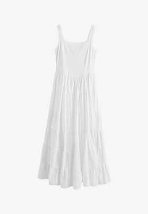 Fehér ujjatlan ruha négyzet alakú nyakkivágással és réteges, lebegő szoknyarésszel, amely a bokáig ér.