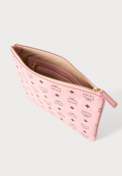 Pochette en cuir rose avec motif répété du logo MCM, fermeture éclair dorée et petite poche intérieure zippée, présentée ouverte en angle.