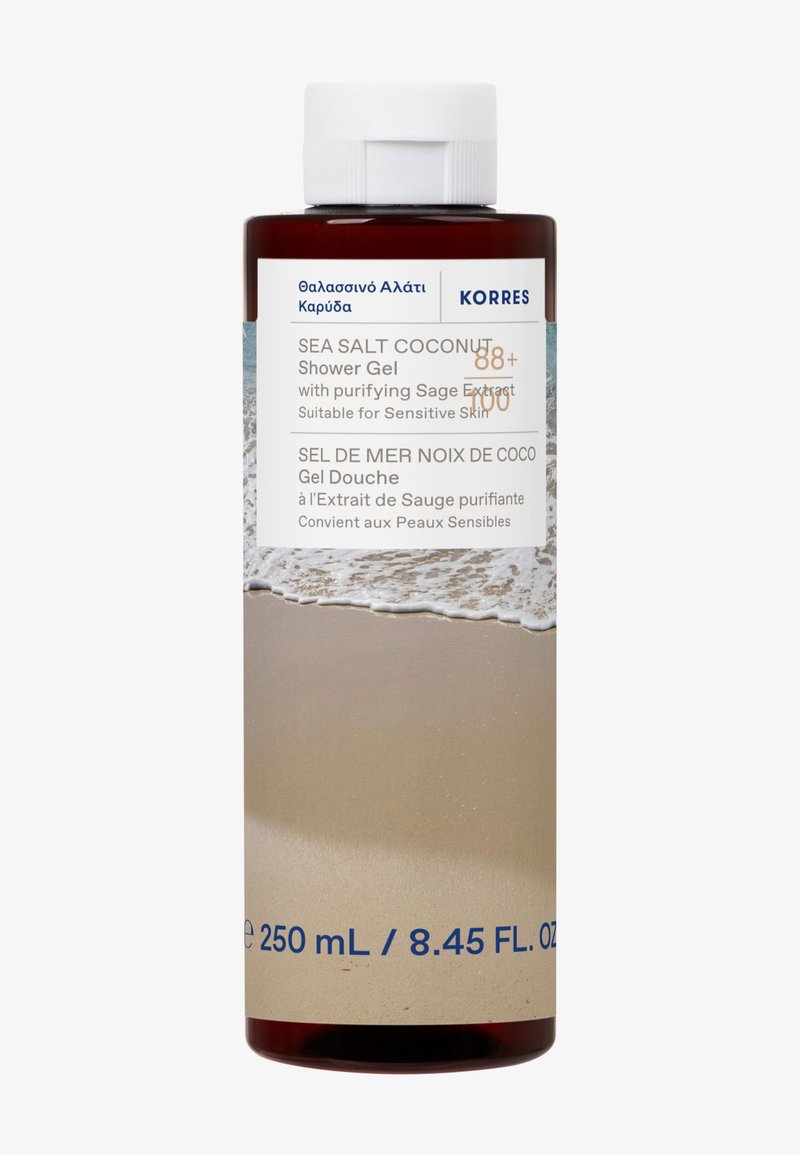 Brązowa plastikowa butelka żelu pod prysznic Korres Sea Salt Coconut z białą zakrętką, niebieskim napisem oraz etykietą na dole przedstawiającą scenę plażową.