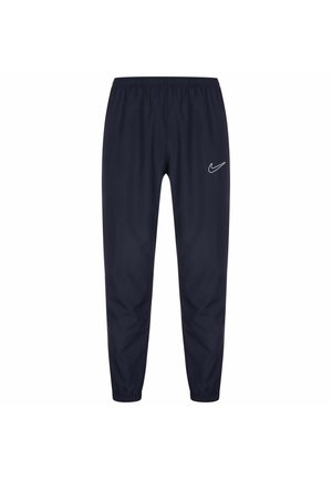 Pantalon de sport bleu marine avec taille et poignets élastiques, arborant un logo blanc Nike swoosh sur la cuisse gauche.