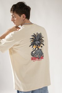 Beige Übergrößen-T-Shirt mit einem bunten Grafikdesign eines Palmenbaums und einer Schlange auf der Rückseite, mit fettem Text "WARNUNG" und "KAOTIKO SOCIETY."