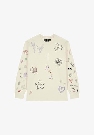 Beige shirt met lange mouwen met verschillende kleurrijke krabbels, waaronder sterren, een schedel, een oog in een hart, kruisen, vogels en de tekst "Mira Paris."