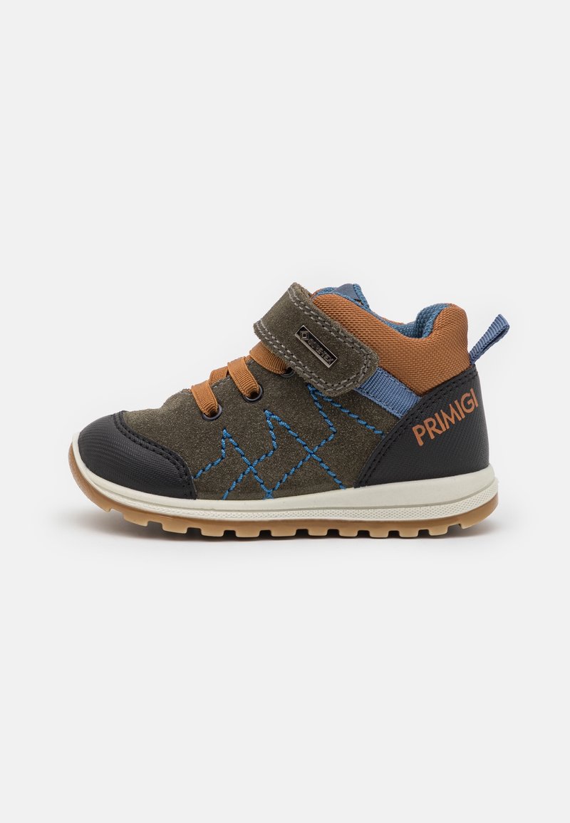 Chaussure montante enfant marron et verte avec coutures bleues, accents orange, bride en Velcro et logo "Primigi" sur le talon.