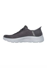 Scarpe slip-on in suede grigio con suola in gomma bianca, caratterizzate da un design elastico e un logo discreto sul lato. Punta arrotondata e cuciture minime.