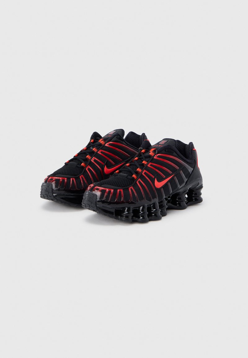Black and red athletic shoes with a mesh upper, wavy patterned accents, and a cushioned sole featuring multiple elongated air chambers.
