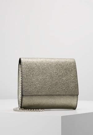 Mała srebrna metaliczna kopertówka z klapką i krótkim srebrnym łańcuszkiem jako uchwytem, spoczywająca na białej powierzchni.