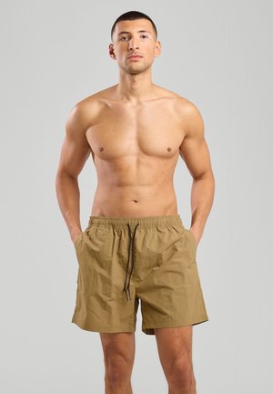 Shorts de bain kaki en tissu léger et texturé. Présentent une taille élastique avec cordon de serrage et des poches latérales.