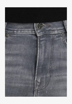 I jean in denim grigio presentano una trama liscia, una chiusura con zip, un distintivo bottone di chiusura e dettagli di cucitura sottili vicino alle tasche e alla vita.