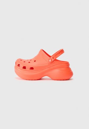 Orange træskosandal med rundet design, lavet af letvægtsmateriale, med ventilationshuller og en bagsnor for støtte.