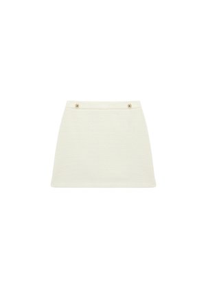 Mini-jupe couleur crème, coupe droite, tissu texturé, avec deux petits boutons décoratifs sur la ceinture.