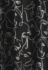 Tissu noir avec un motif de dessin abstrait de visages en lignes blanches, présentant des épaisseurs variées et des designs superposés, créant profondeur et texture.