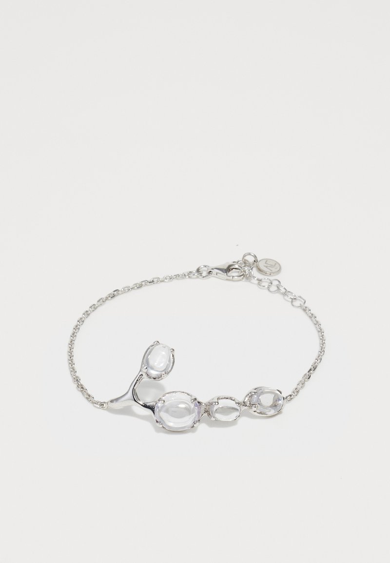 Sudraba apro ar pieciem dažādiem caurspīdīgiem akmeņiem, iestikoti gludās metāla formās, ar smalku ķēdīti un omāku aizdari.