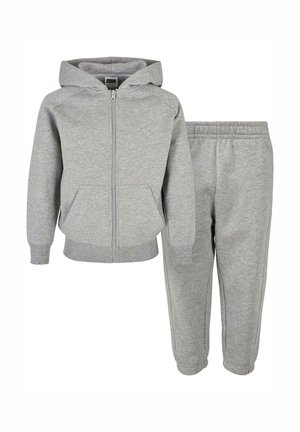 Haut en coton gris avec fermeture éclair et poches latérales, associé à un pantalon de survêtement assorti avec une taille élastique et des chevilles fuselées.