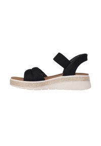Sandale en tissu noir avec deux brides croisées, une bride élastique à l'arrière et une semelle compensée présentant une texture tissée et un fond en caoutchouc crème.