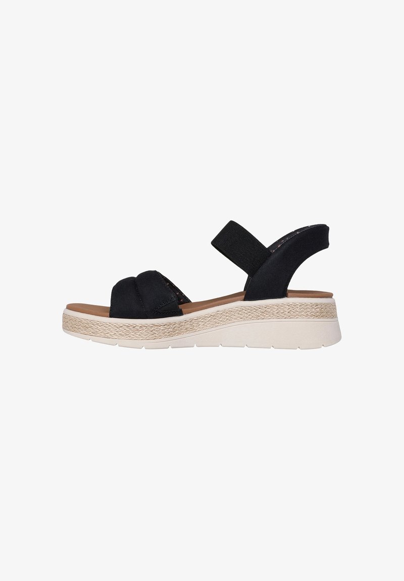 Sandale en tissu noir avec deux brides croisées, une bride élastique à l'arrière et une semelle compensée présentant une texture tissée et un fond en caoutchouc crème.