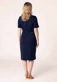 Hemdblaues, tailliertes Kleid mit kurzen Ärmeln, Rückennaht und goldenen Knopfdetails an der Taille. Glattes Material und knielanges Design.