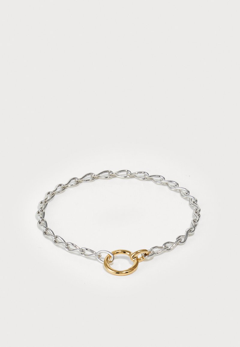 Bracciale in argento con maglie torcigliate e un accento circolare dorato al centro, caratterizzato da una finitura metallica liscia.