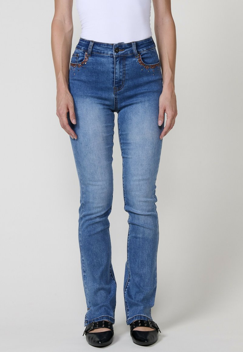 Vaaleansiniset korkeavyötäröiset farkut, joissa on hieno haalistuma, koristeompelut ja tiukka suora lahjemuoto.