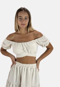 Off-shoulder cropped top van lichte, gestructureerde stof met pofmouwen. Gecombineerd met een gerimpelde rok met elastische taille in bijpassende kleur.