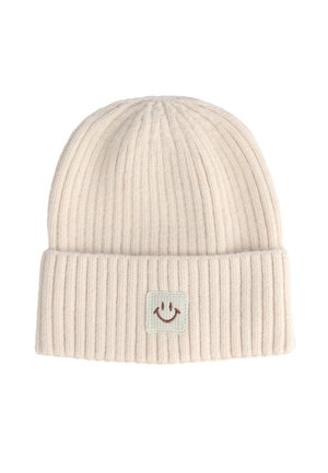 Beanie a coste di un leggero beige con risvolto e un'etichetta quadrata con un design di faccia sorridente. Texture morbida con una vestibilità aderente.