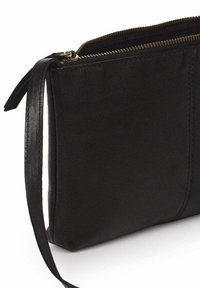 Bolso de mano de cuero negro con una textura suave, que presenta un cierre con cremallera y una delgada correa de muñeca de cuero en el lateral.