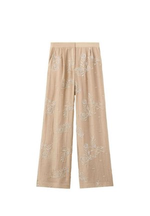 Pantalon beige à jambes larges avec une broderie florale blanche subtile et une taille élastique, posé à plat sur un fond blanc.