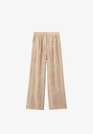 Pantalon beige à jambes larges avec une broderie florale blanche subtile et une taille élastique, posé à plat sur un fond blanc.
