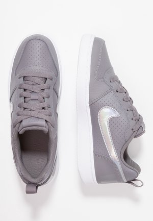 Coppia di scarpe da atletica grigie con suole bianche e swoosh argento iridescente, allacciate, una scarpa vista dall'alto, una scarpa vista di lato.