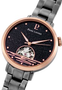 Reloj analógico con una esfera negra brillante, acentos en oro rosa, fondo de caja transparente y brazalete de acero inoxidable. Presenta un diseño minimalista.