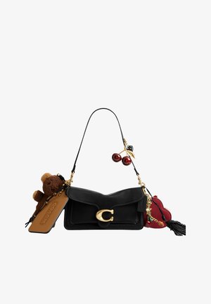 Zwarte leren schoudertas met gouden sluiting, versierd met een teddybeer, een cognackleurig label, een rood hartjesbedel, kersen- en dobbelsteenornamenten, en een zwarte kwast.