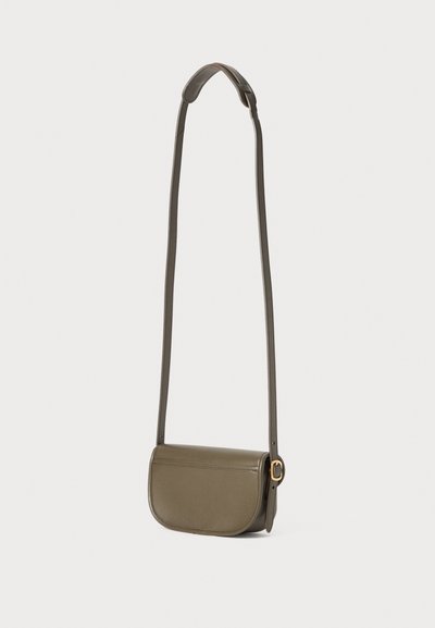 Sac bandoulière en cuir vert olive avec un rabat courbé, une bandoulière fine et des accessoires en métal doré. Design lisse et structuré avec une esthétique minimaliste.