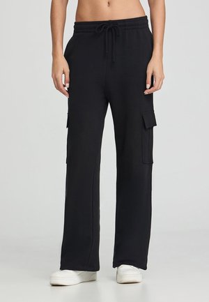 Pantaloni cargo neri con vestibilità rilassata, realizzati in tessuto morbido, dotati di tasche laterali e una vita elasticizzata con coulisse.