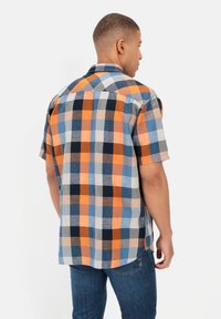 Korte mouwen geruite shirt in blauw, oranje en zwart. Dit shirt heeft een button-down kraag en een rechte zoom, weergegeven vanuit de achterkant.