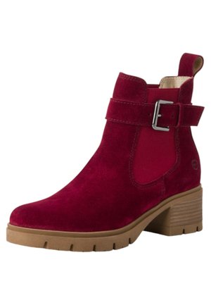 Stivaletto in suede bordeaux con tacco a blocco imbottito, pannelli laterali elasticizzati e un accento in metallo sulla cinghia.