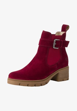 Bottine en daim bordeaux avec un talon bloc rembourré, des panneaux latéraux élastiques et un accent de boucle métallique sur la sangle.