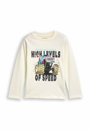 Langarm-Cream-T-Shirt mit einem blauen und roten Monstertruck-Graphic, oversized grünen Reifen und fettem schwarzen Text: "HOHE GESCHWINDIGKEITSLEVEL."