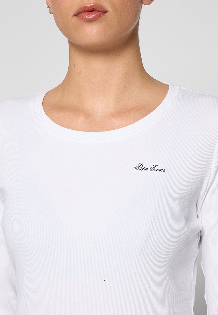 T-shirt blanc à manches longues avec une texture côtelée, présentant un décolleté en scoop et un logo "Pepe Jeans" noir sur la partie gauche de la poitrine.