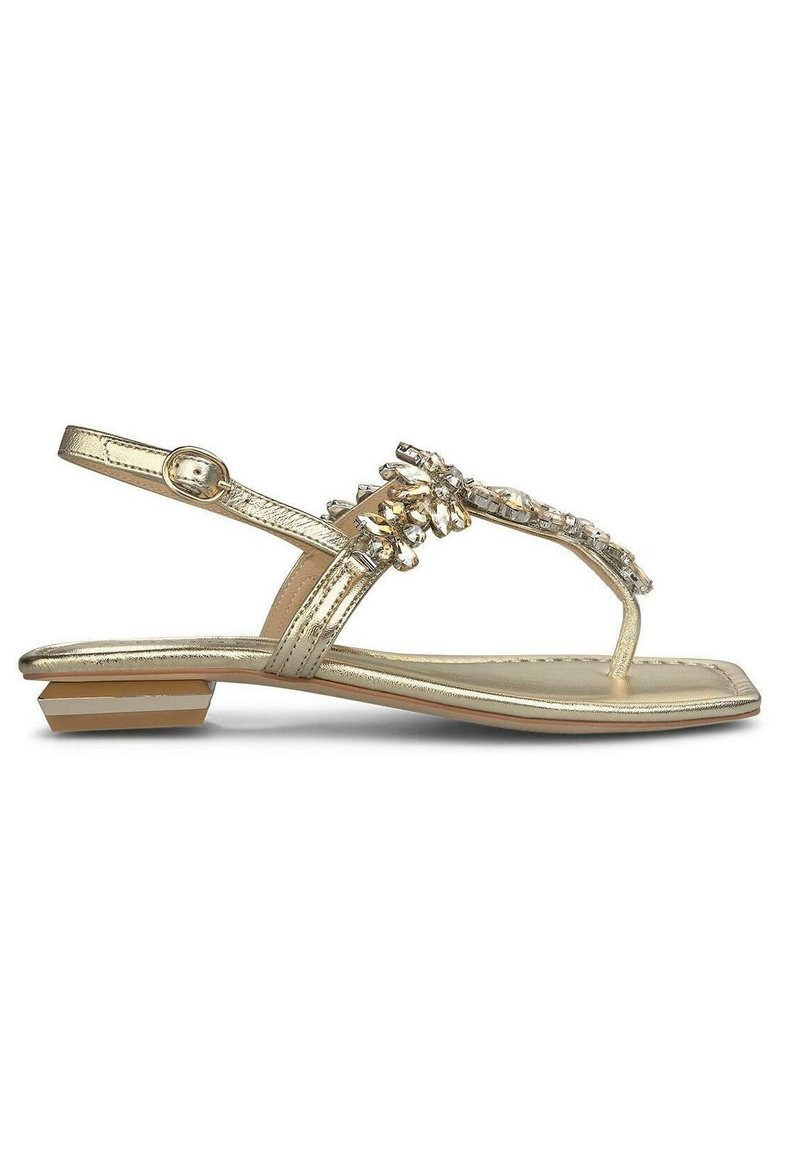 Gouden metallic sandalen met een platte zool, voorzien van een decoratieve rhinestone-bemessing op de bovenkant en een achterband voor ondersteuning.