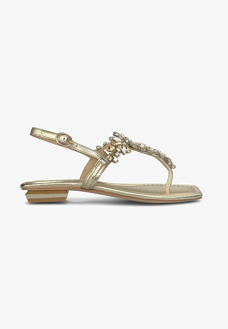 Gouden metallic sandalen met een platte zool, voorzien van een decoratieve rhinestone-bemessing op de bovenkant en een achterband voor ondersteuning.