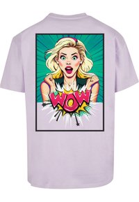 Camiseta lila con un gráfico estilo cómic de un personaje sorprendido, con letras en negrita que dicen "WOW", colores vibrantes y un fondo de explosión estelar.